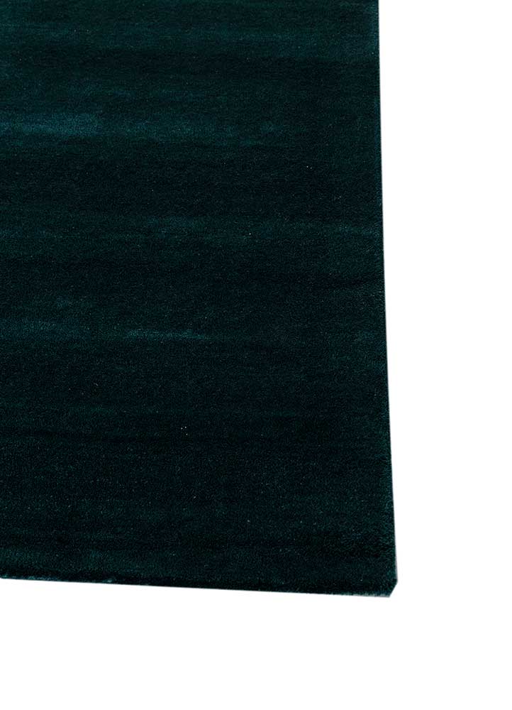 Corner view of hand tufted wool rug showing abstract layered wave design, rich colors and fine edge detailing.