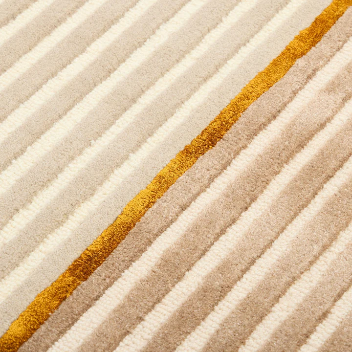 Close up pattern detail of Aurel Gold Line Rug hand tufted wool rug with fine linear texture.