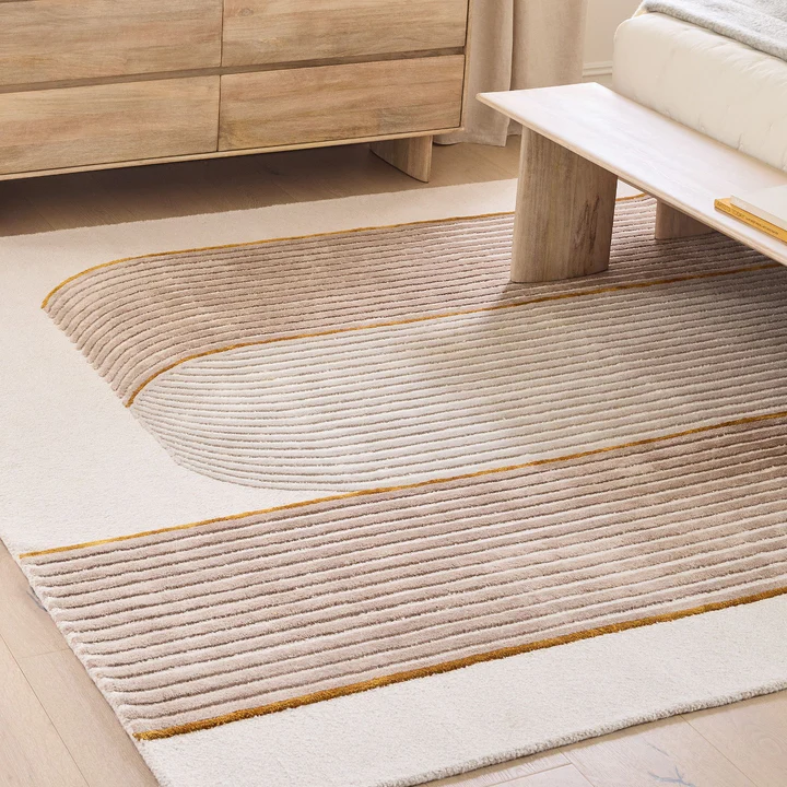 Styled interior view of Aurel Gold Line Rug hand tufted wool rug in modern living space.