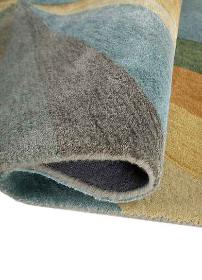 Folded corner of Aurora Rays hand tufted wool rug showing thickness and texture.