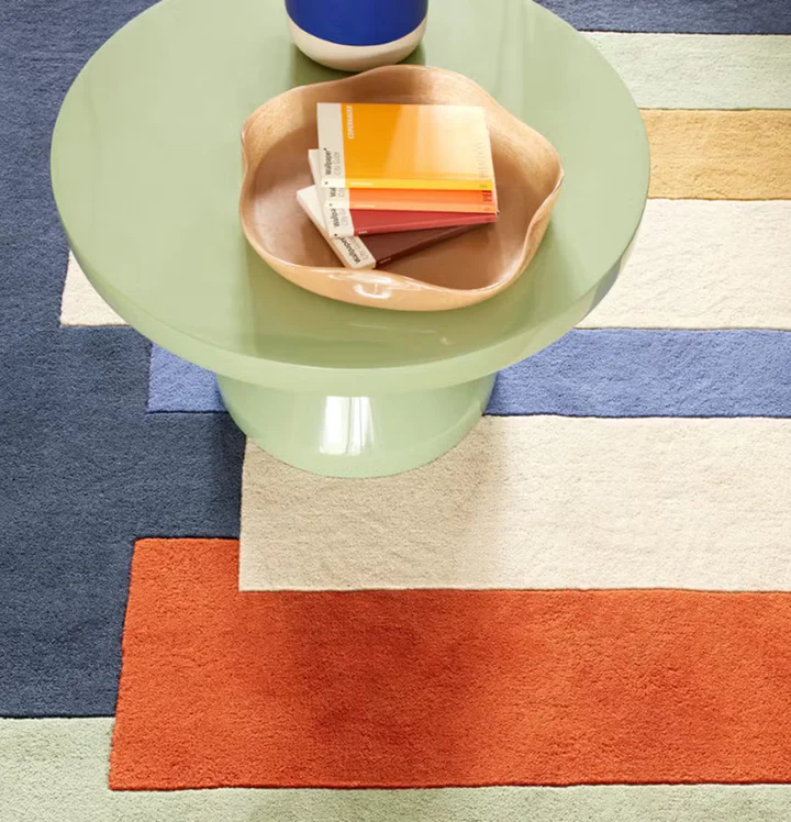 Axis Blocks Multicolor hand tufted wool rug detail view with table showing modern block pattern and vibrant multicolor tones.