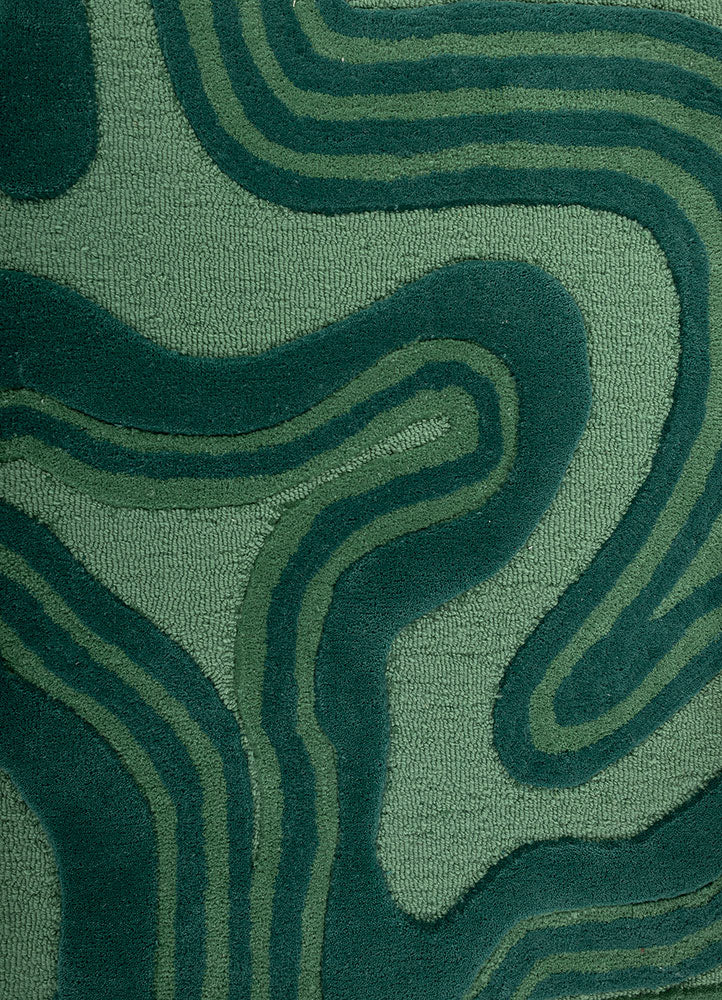 Close up of Cascade Wool Rug hand tufted wool rug showing flowing abstract green design.