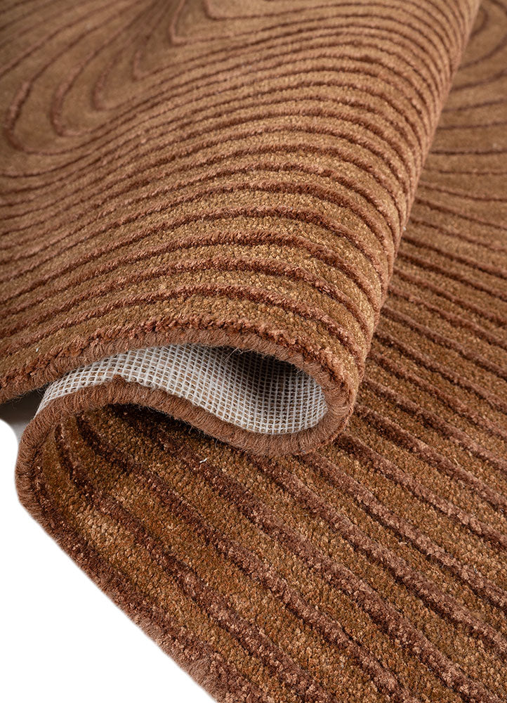 Folded edge view of Clay Ripple Wool Rug highlighting thickness and soft hand tufted wool pile.