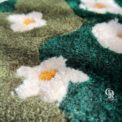 Close-up texture of hand-tufted green floral rug showing white daisy pattern and plush wool fibers.