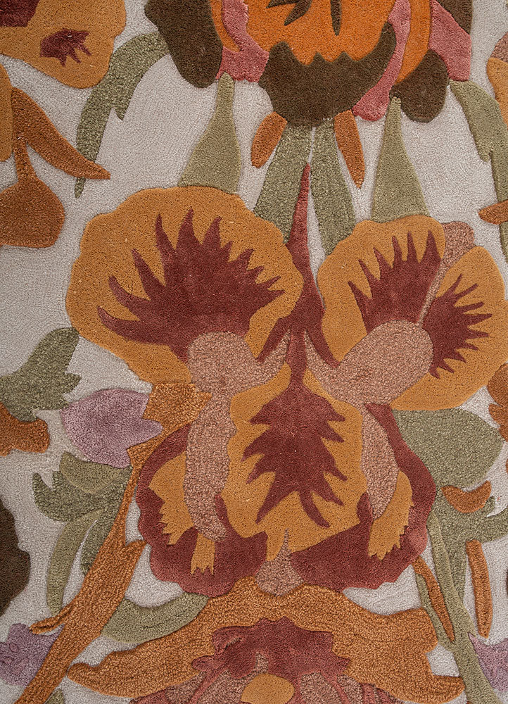 Hand tufted wool rug close view showcasing ornate floral motifs fine detailing rich color layers and soft textured wool surface.