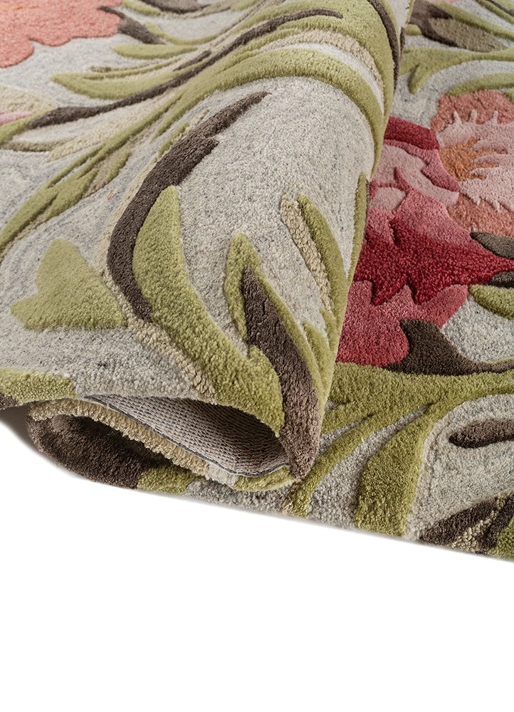 Hand tufted wool rug rolled to show plush thickness soft pile height and detailed floral pattern crafted in premium wool.