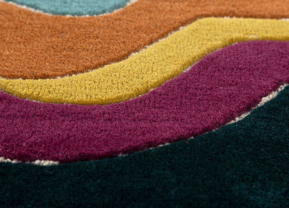 Close view of hand tufted wool rug showing layered wave pattern, soft texture and detailed craftsmanship.