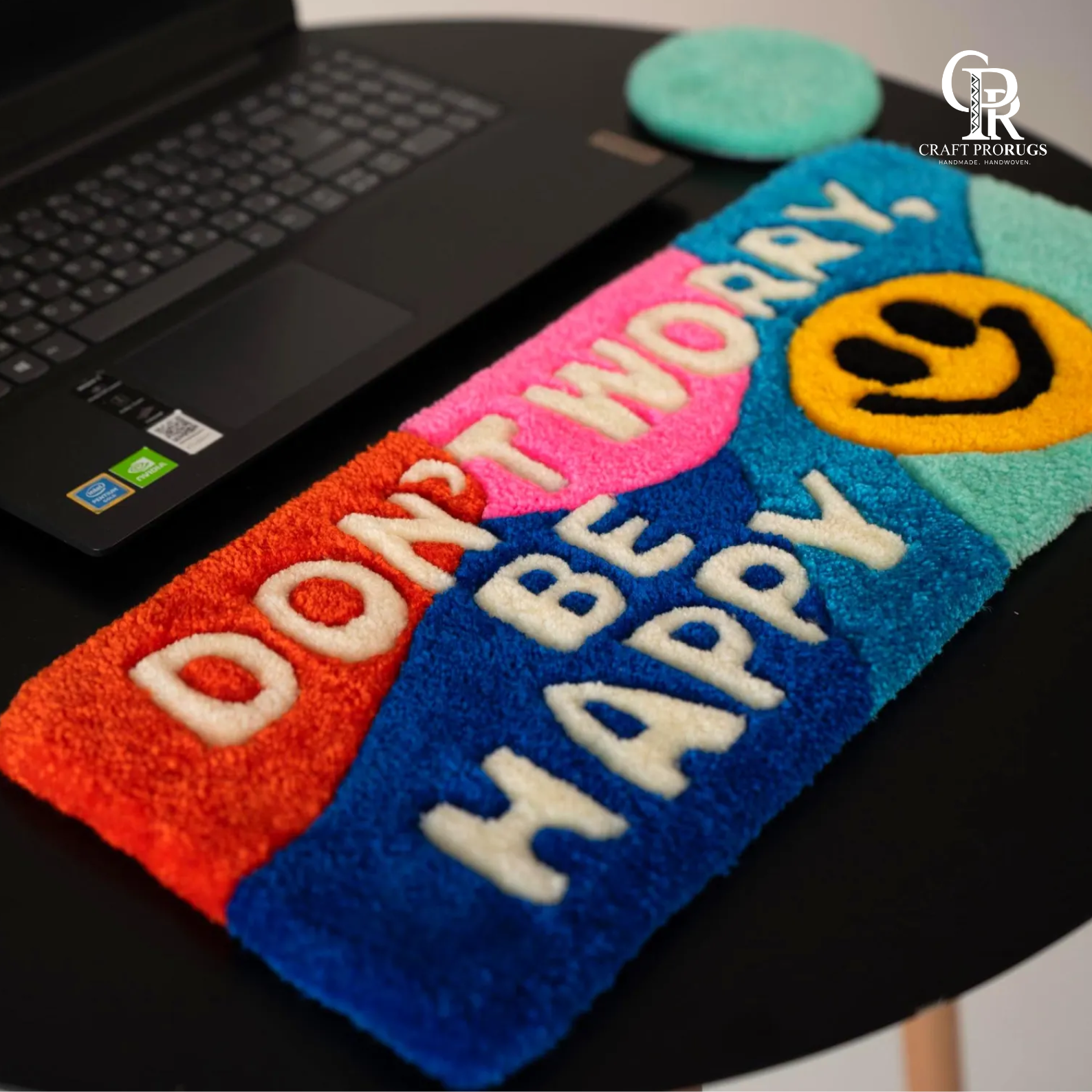 Angled view of Be Happy Desk Rug showing ergonomic wrist rest shape and vibrant rainbow stripe pattern