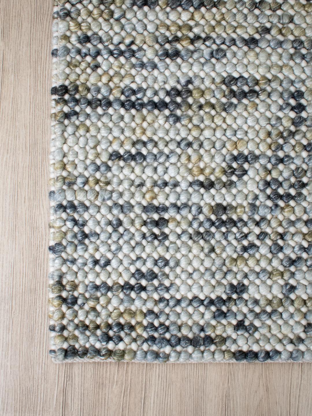 Corner view of Chalkstone Pebble flatweave rug showing textured weave, pebble-inspired pattern, and soft neutral chalk tones in detail.