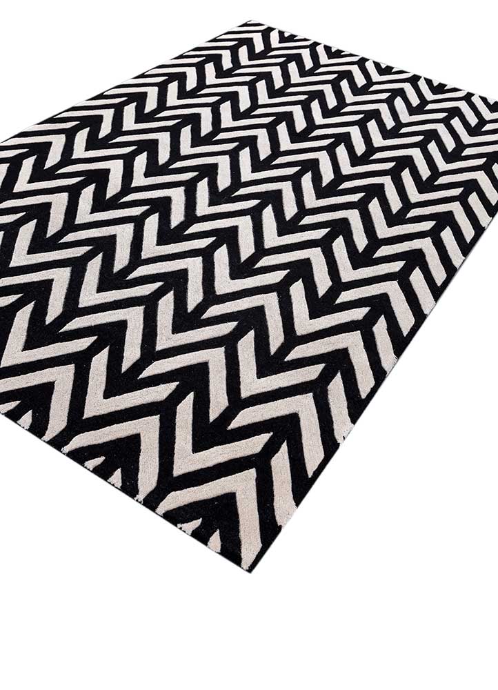 Black and ivory hand tufted wool rug showing chevron zigzag design from angled view with rich texture.