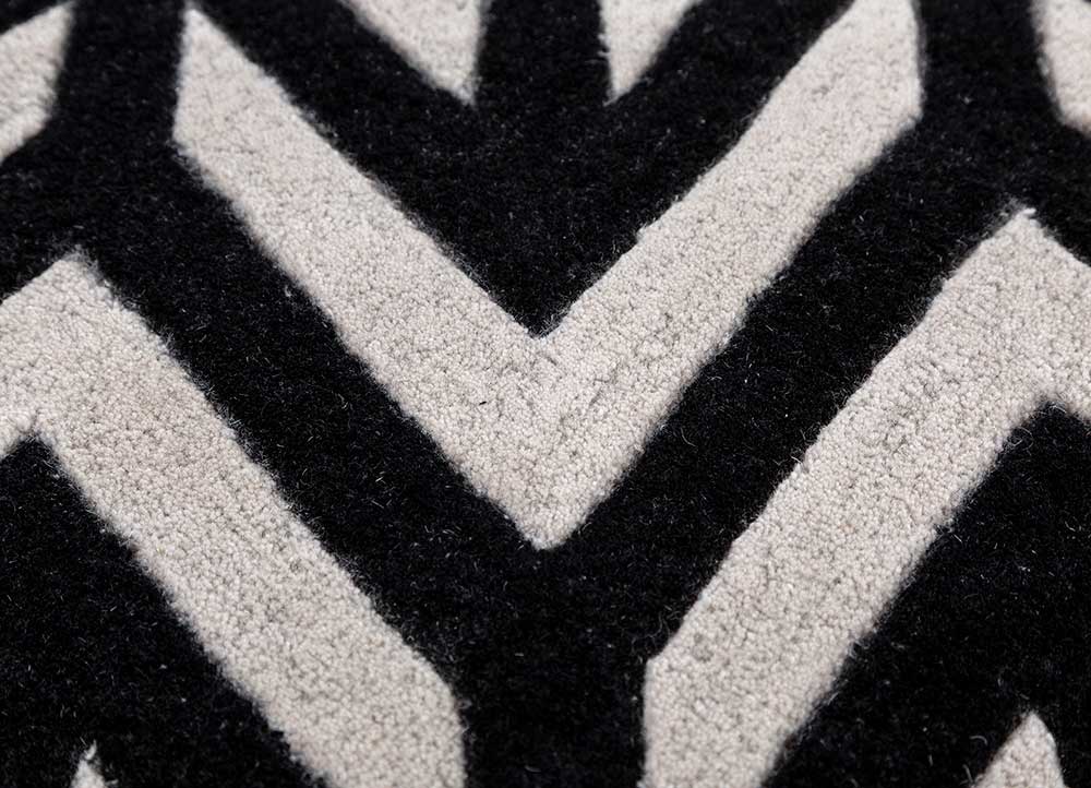 Close view of hand tufted wool rug highlighting soft pile texture and bold black ivory chevron pattern.
