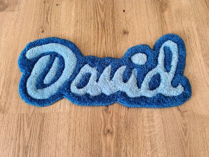 Blue hand-tufted rug featuring the name ‘David’ on a wooden floor