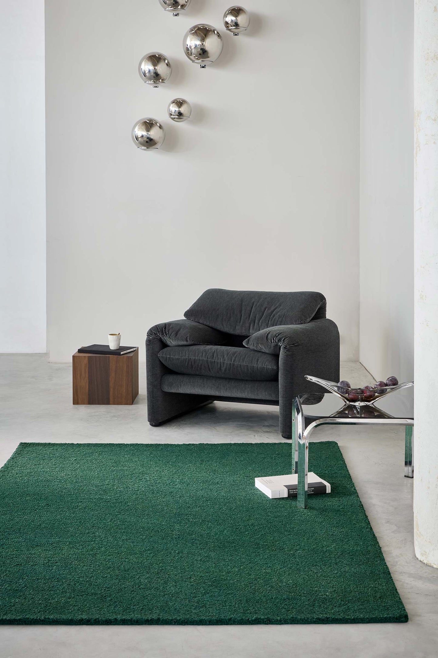 Echo Forest Solid hand tufted wool rug styled in a modern living room with a calm forest green color.