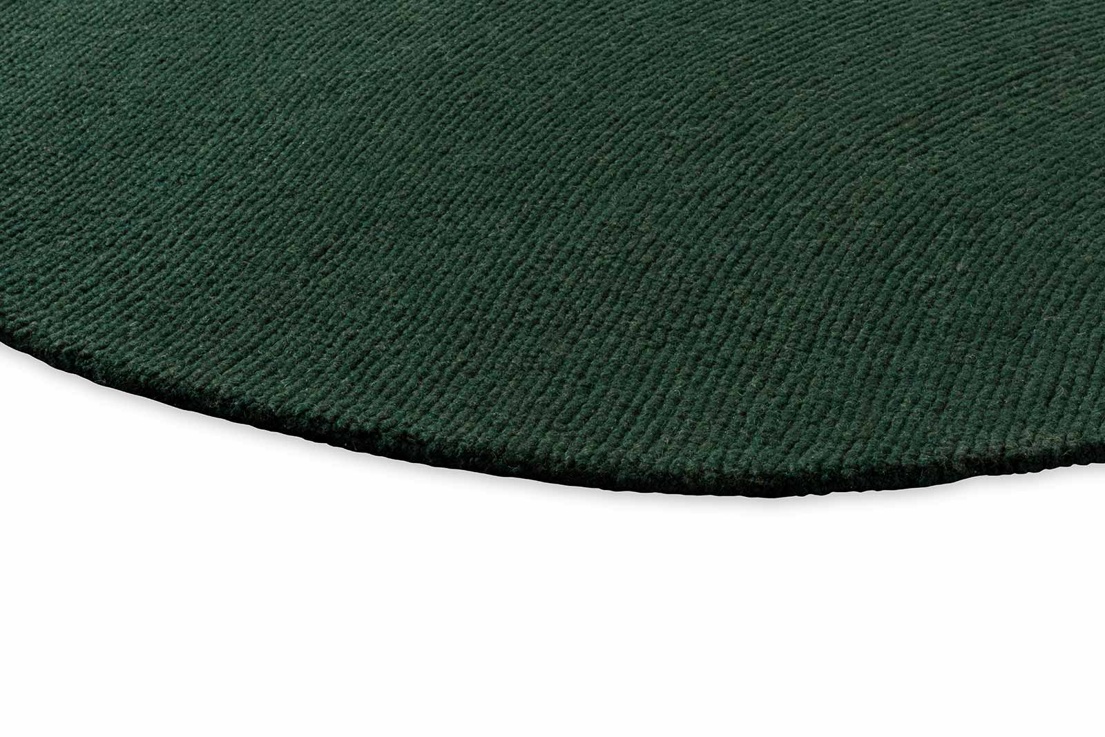 Round Echo Forest Solid hand tufted wool rug featuring smooth edges and uniform forest green wool texture.