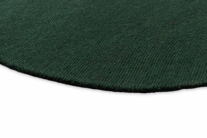Round Echo Forest Solid hand tufted wool rug featuring smooth edges and uniform forest green wool texture.