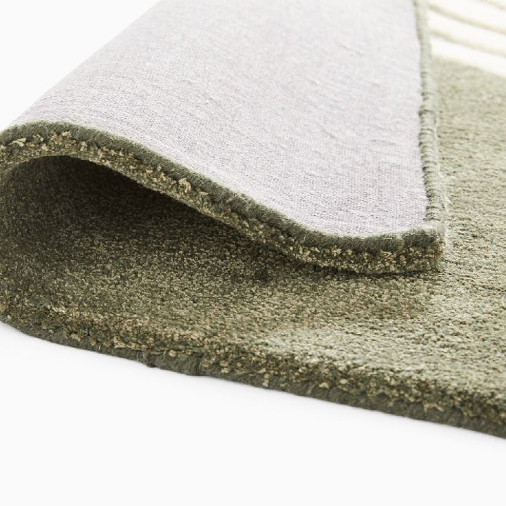 Corner fold detail of Elora Sage Oval hand tufted wool rug showing thickness texture and premium wool finish.