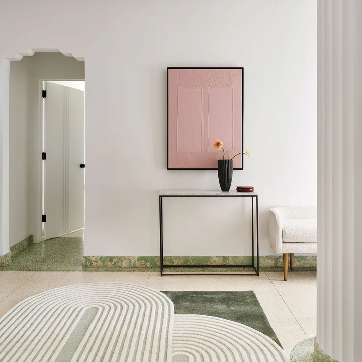 Elora Sage Oval hand tufted wool rug placed in a minimal interior showing oval shape and sage tone.