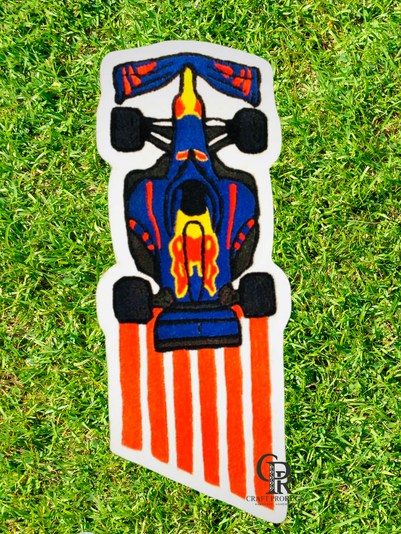 hand-tufted formula racing car rug Top view showing bold blue and orange design with soft plush pile for kids room décor