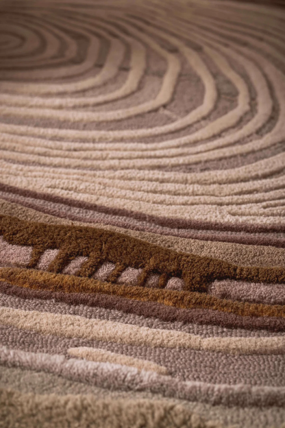 Close-up of hand-tufted Sandstone Swirl Rug showing plush pile, detailed ripple pattern, and warm beige and sand tones texture.

