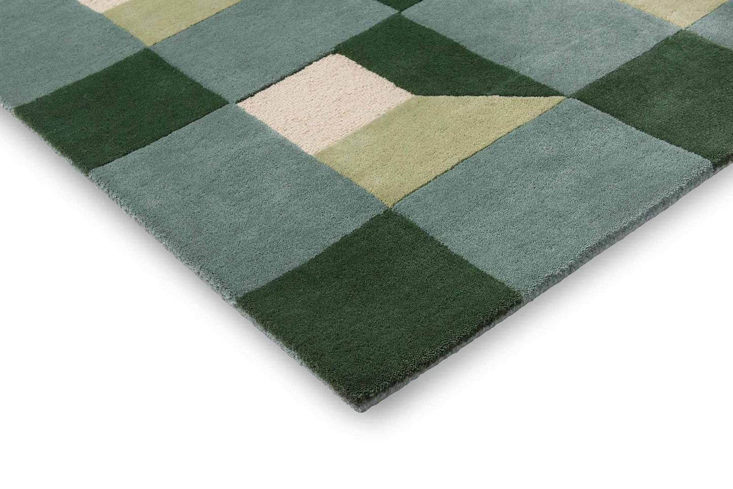 corner of harlequin geometric rug showing precise hand-tufted geometric pattern in green cream shades.