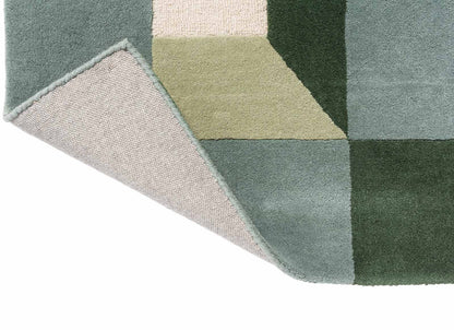 folded harlequin geometric rug showing texture and quality of hand-tufted wool in green cream colors.