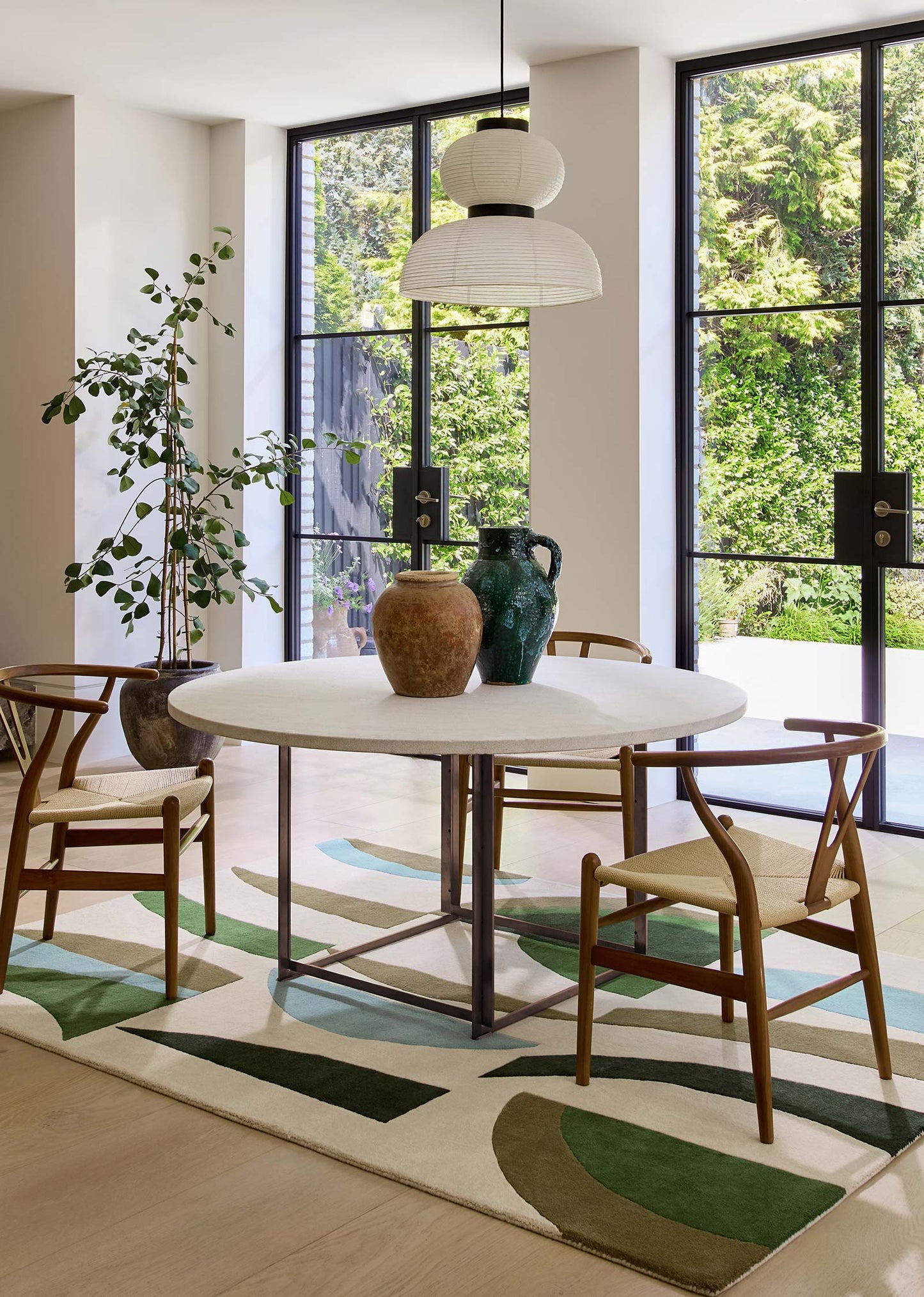 Interior lifestyle view of Harlequin Torillo hand tufted wool rug placed in a modern living and dining space.