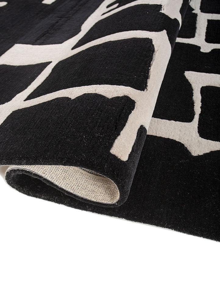 Rolled detail of Linear Grid Black and Ivory hand tufted wool rug showing plush pile flexible structure and clean finish.