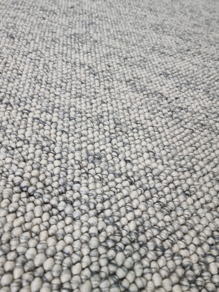 Macro close-up of pebble texture flatweave pure wool rug detailing looped wool yarns