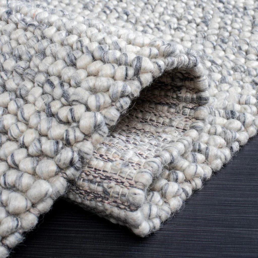 Pebble texture flatweave pure wool rug showing folded edge and handwoven thickness