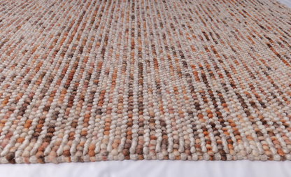 Close-up of Pebbles Copper flatweave rug showing detailed weave texture, subtle color variation, and pebble-inspired pattern