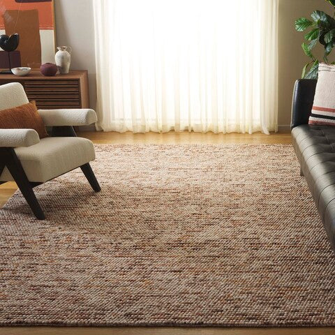 Top view of Pebbles Copper flatweave rug showing warm earthy tones and pebble-inspired texture in a living room