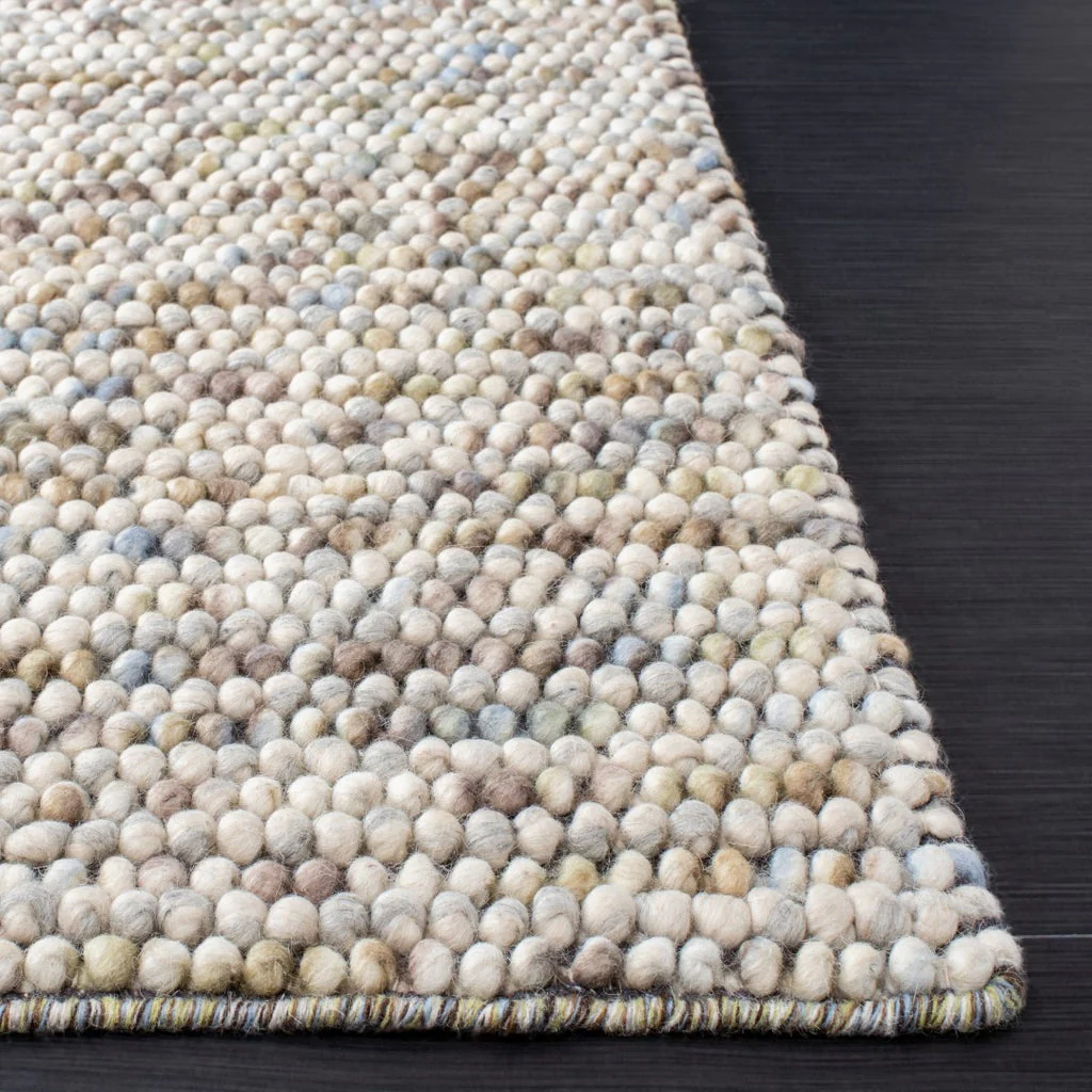 Edge view of Pebbles Multi Ivory flatweave rug, showcasing thick hand-woven loops and flat low-profile structure