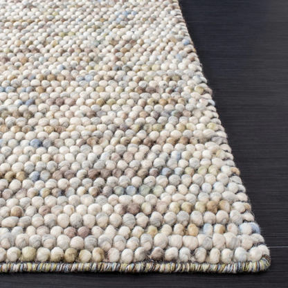Edge view of Pebbles Multi Ivory flatweave rug, showcasing thick hand-woven loops and flat low-profile structure
