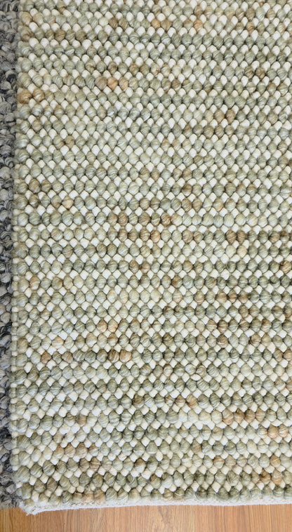 Close-up of Pebbles Sage Green round flatweave rug texture showing detailed weave and natural sage green tones.