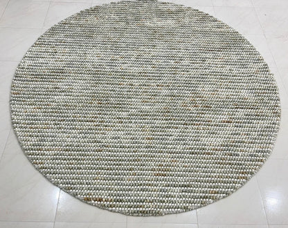 Pebbles Sage Green round flatweave rug in living room setup adding style and warmth to the space.