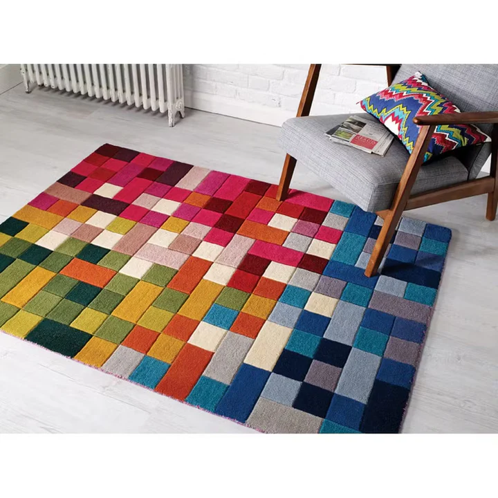 Pixelia spectrum hand tufted wool rug styled in a modern living room featuring colorful pixel pattern beside a chair.