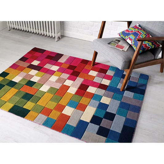 Pixelia spectrum hand tufted wool rug styled in a modern living room featuring colorful pixel pattern beside a chair.