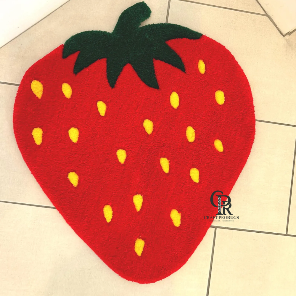 Top close view of strawberry shaped red hand-tufted rug with detailed yellow seed pattern.