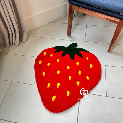 Strawberry shaped hand-tufted rug placed near wooden chair in a living room for floor decor display.