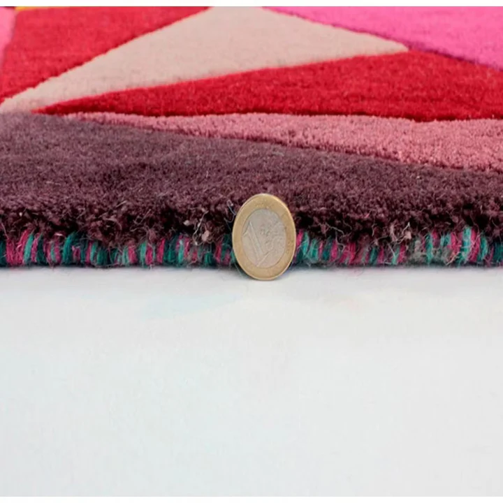 Close up edge view of vivid geometry hand tufted wool rug showing thickness dense pile and fine craftsmanship