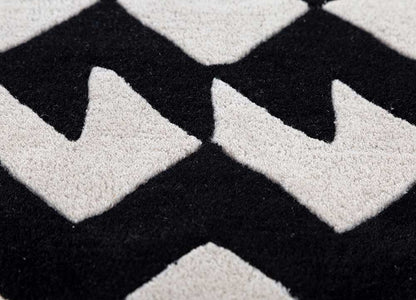 Close-up of zigzag monochrome wool rug showing black and white hand-tufted geometric pattern